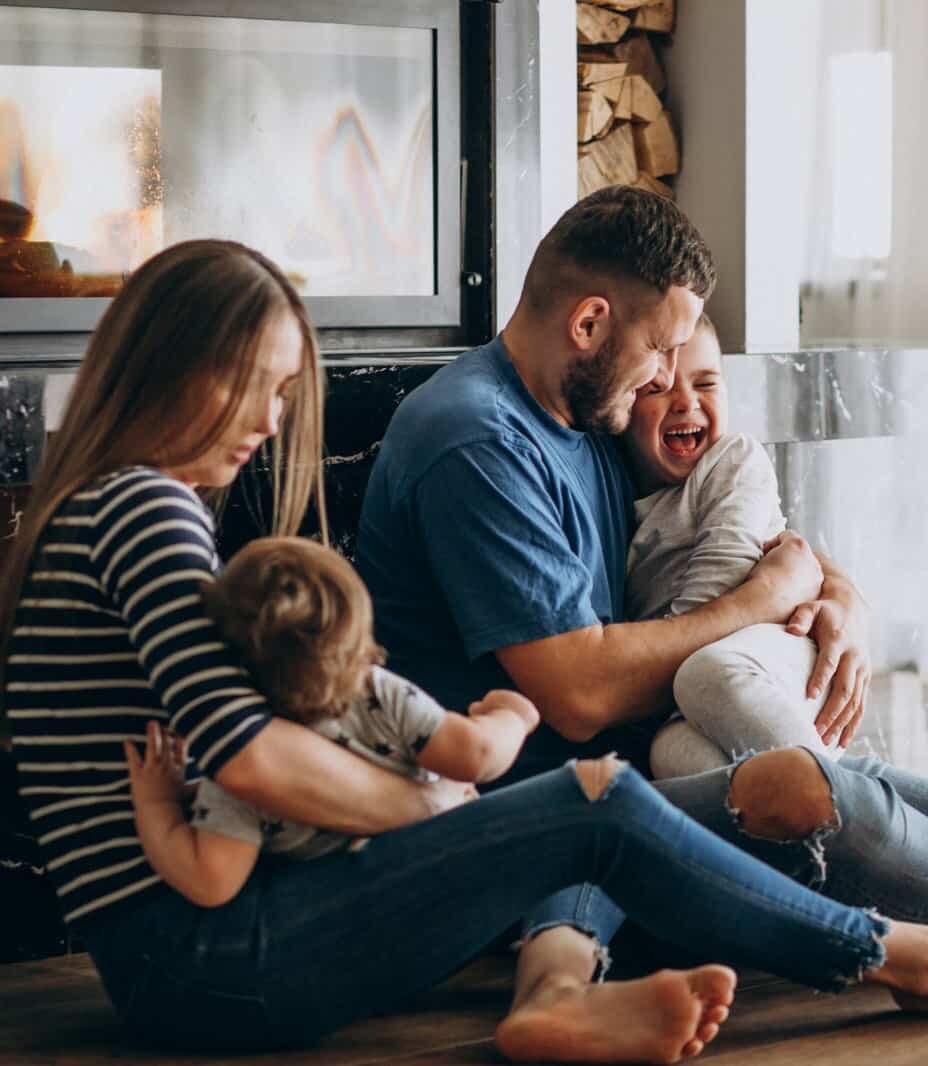 joven-familia-dos-hijos-casa (1) Pareja con dos hijos felices en casa